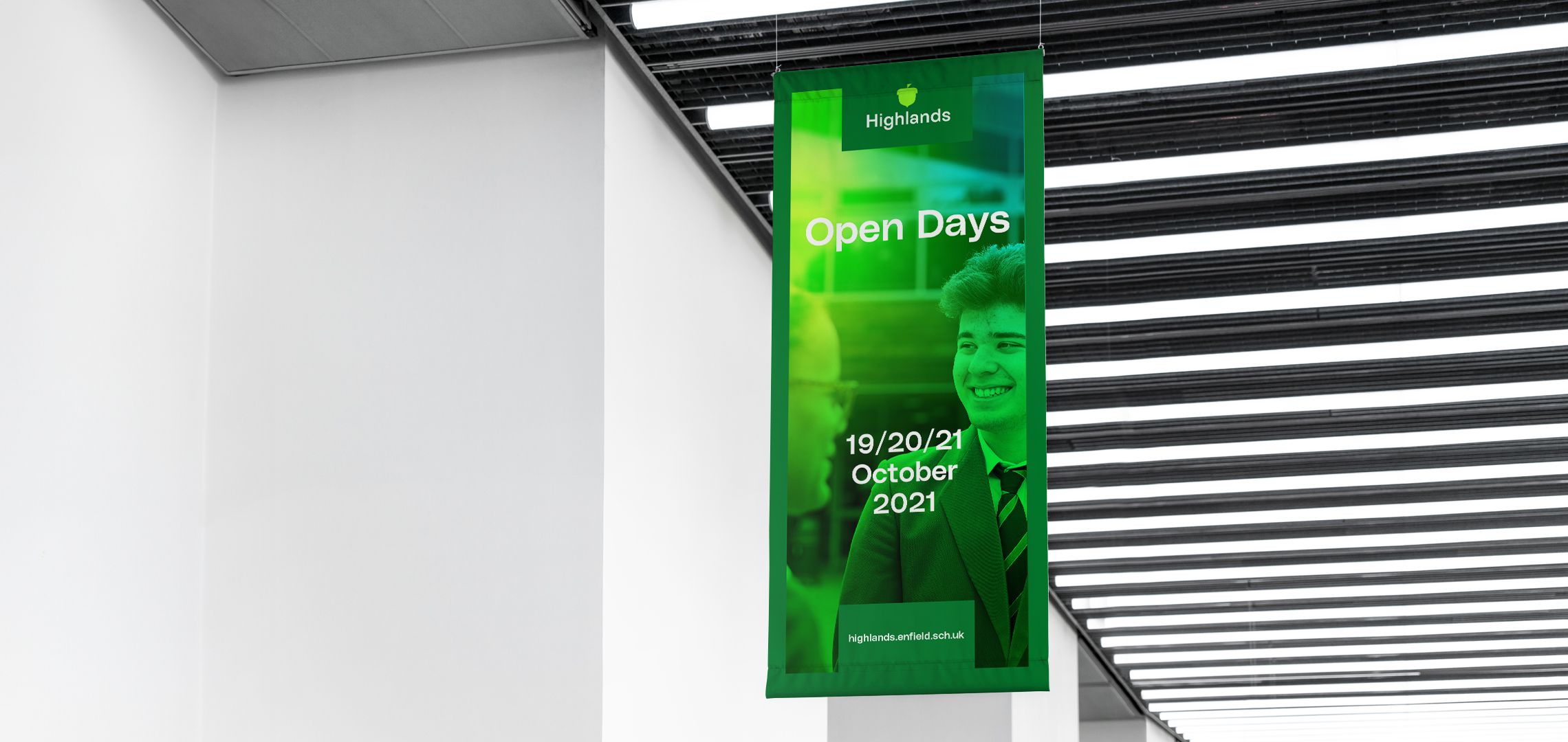 Banner hanging from a ceiling, promoting the dates of school open days. Featuring a photograph of some students, coloured in a gradient of bright greens, blues and yellows