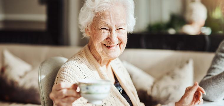 Elderly lady smiling with a cup of tea