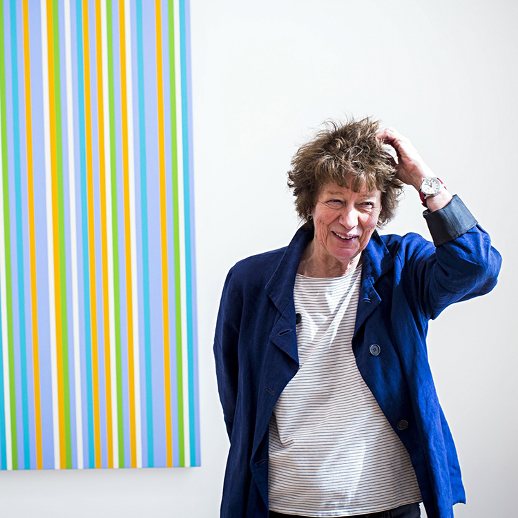 Artist Bridget Riley in front of one of her pieces