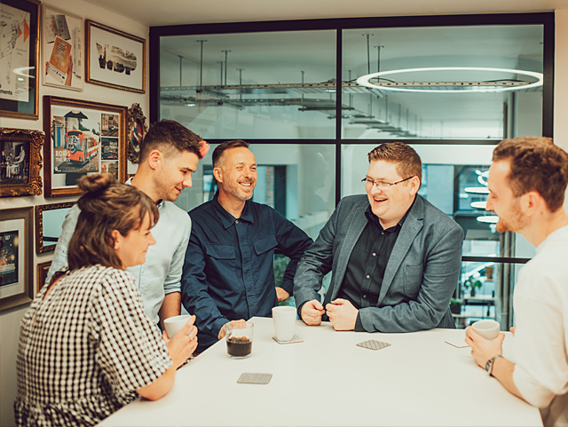 An IE project team holding a meeting in one of the meeting rooms overlooking the studio