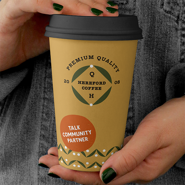 Mock up of a coffee cup printed with 'Talk Community partner' branding