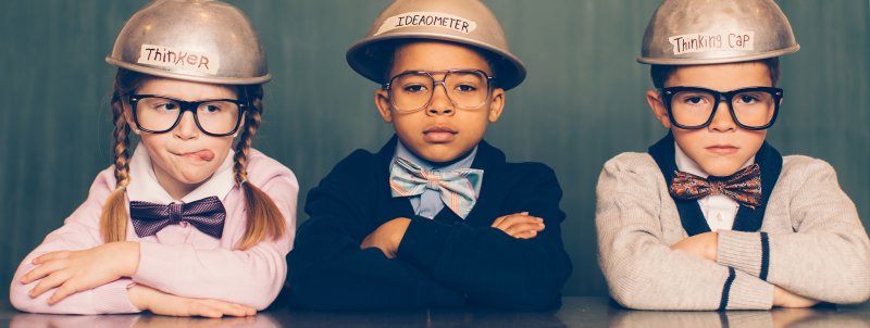 Disruption: three kids in metal "thinking caps", girl on left is sticking her tongue out