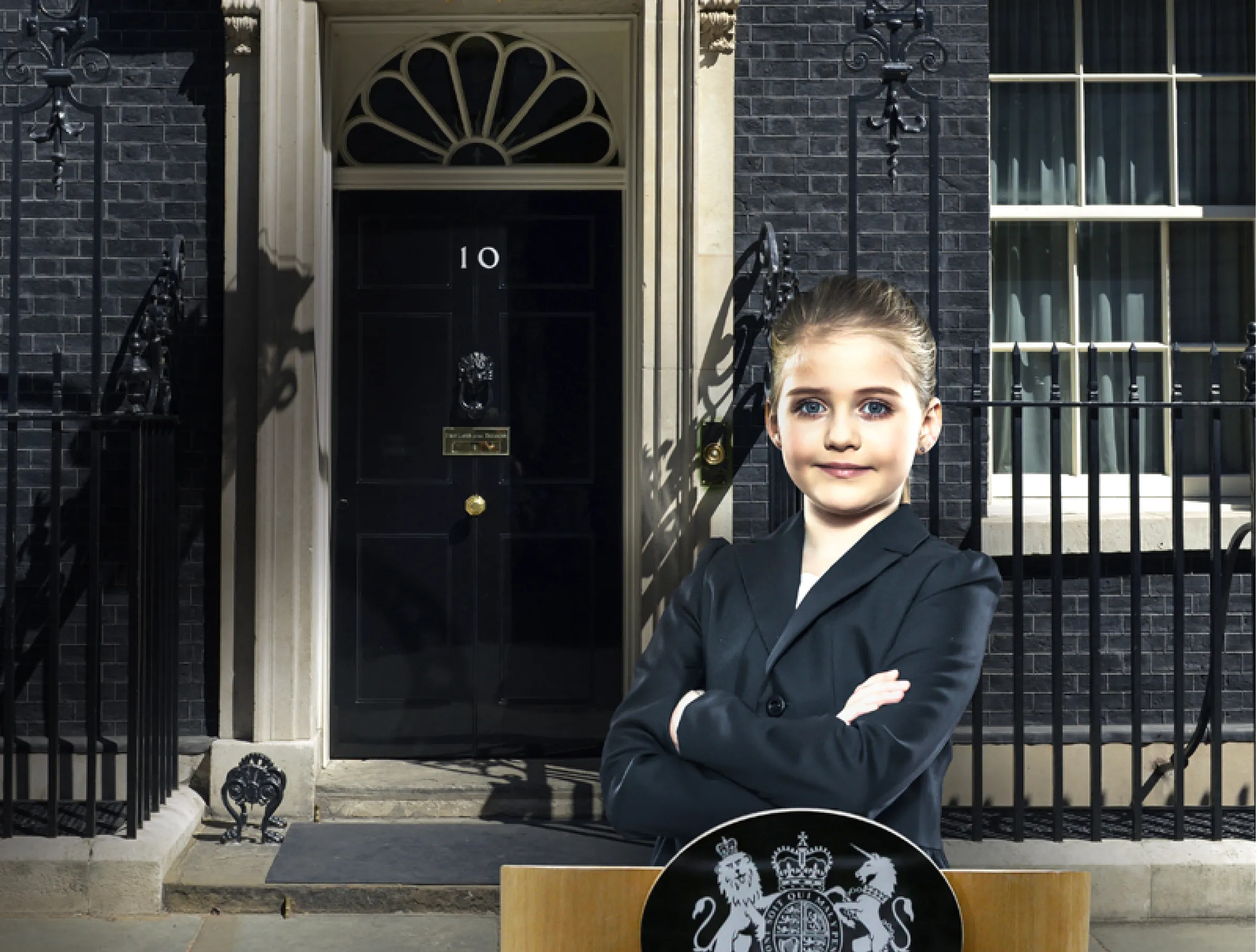 Teach First "Challenge the Impossible" campaign image showing a young girl standing by a lectern outside 10 Downing Street. She has her arms folded and is smiling, looking powerful